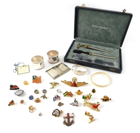 A Yves Saint Laurent gentleman's grooming set, Arthur Price EPNS cuff links, various cap badges and lapel badges, silver child's bangle, silver folding vesta and a gold plated bangle. (a quantity)