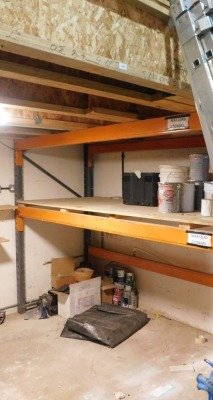 The mezzanine and pallet racking, comprising two support stanchions and a timber decking. VAT is also payable on the hammer price of this lot.