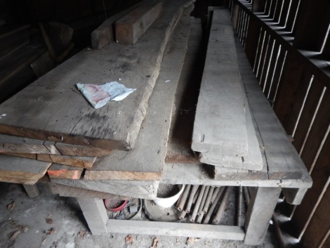 A quantity of timber planks and a bench table.