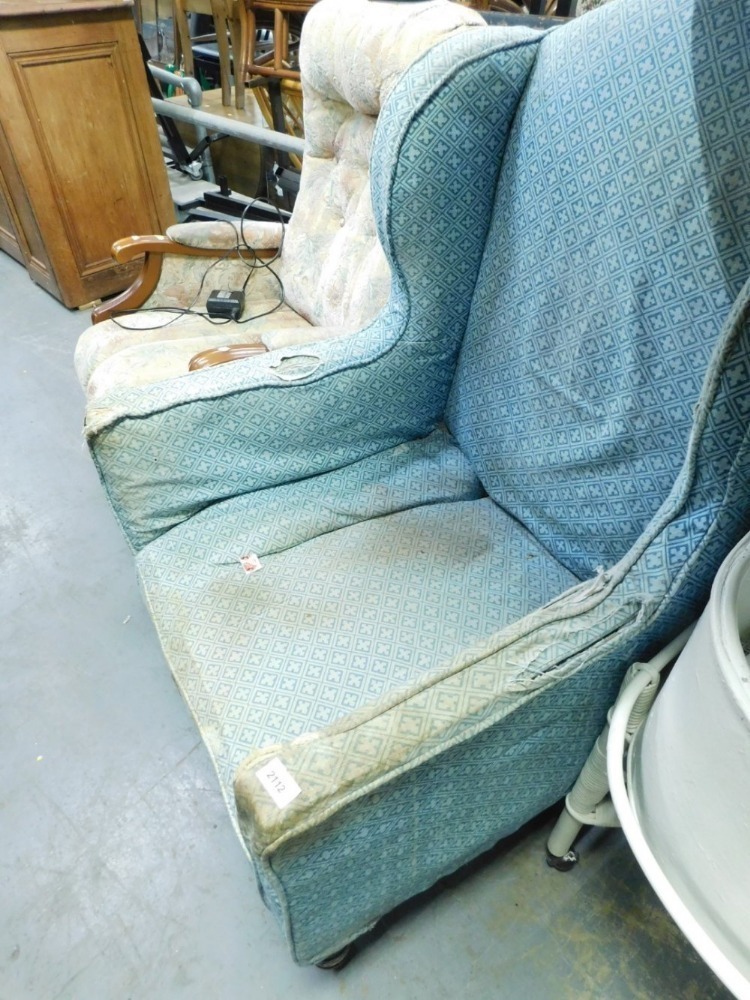 A 20thC wing armchair, with Howard style deep seat, on turned front