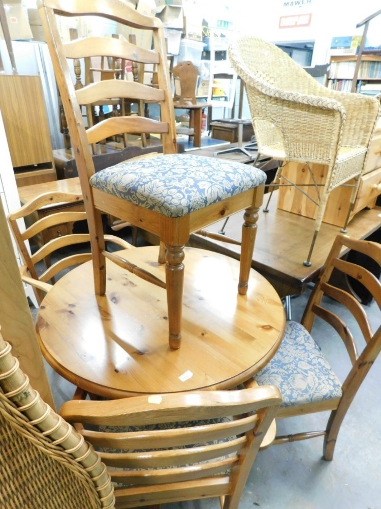 A pine Ducal circular dining table and four chairs, to include two carvers.