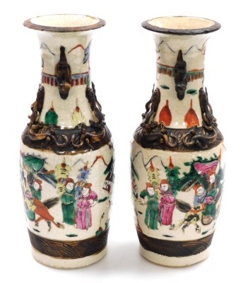 A pair of Chinese crackle glaze vases, of baluster form, with applied dog of fo handles and chilin to the neck, the body depicting a battle scene with figures on horseback, four character mark, 29.5cm high. - 15