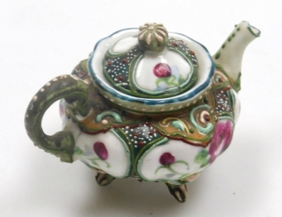 Two miniature teapots, comprising a Chinese Yixing example, decorated in enamels with flowers and butterflies, 4cm high, (AF), and a Japanese Nippon moriage decorated teapot, 5cm high. - 12