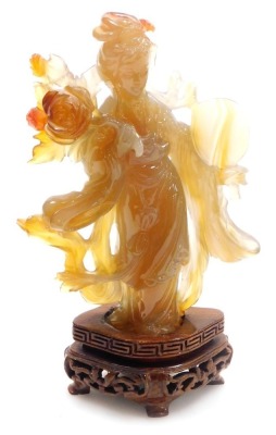 A Chinese agate figure of Guanyin, modelled standing holding a hand mirror, and a lotus flower, raised on a hardwood base, 16cm high. - 6