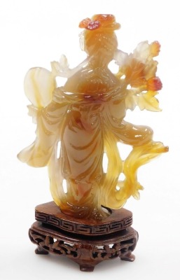 A Chinese agate figure of Guanyin, modelled standing holding a hand mirror, and a lotus flower, raised on a hardwood base, 16cm high. - 8