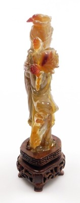 A Chinese agate figure of Guanyin, modelled standing holding a hand mirror, and a lotus flower, raised on a hardwood base, 16cm high. - 9