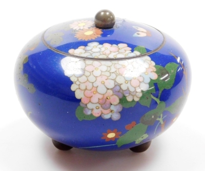 A Japanese Meji period cloisonne enamel koro and cover, of globular form, decorated with flowers, blossom and butterflies on a blue ground, on three bun feet, 10cm wide, together with a Japanese Meiji period cylindrical box and cover decorated with flower - 15