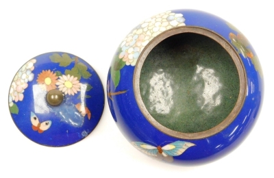 A Japanese Meji period cloisonne enamel koro and cover, of globular form, decorated with flowers, blossom and butterflies on a blue ground, on three bun feet, 10cm wide, together with a Japanese Meiji period cylindrical box and cover decorated with flower - 18