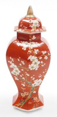 A late 19thC Japanese porcelain vase and cover in the Chinese style, of faceted baluster form, decorated with prunus on an iron red ground, 31cm high. - 9