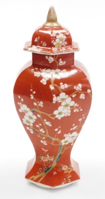 A late 19thC Japanese porcelain vase and cover in the Chinese style, of faceted baluster form, decorated with prunus on an iron red ground, 31cm high. - 11