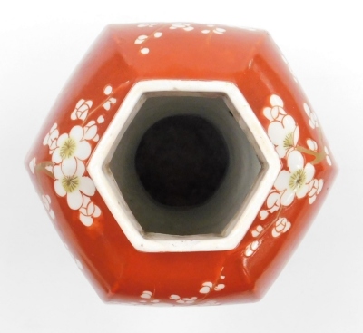 A late 19thC Japanese porcelain vase and cover in the Chinese style, of faceted baluster form, decorated with prunus on an iron red ground, 31cm high. - 13