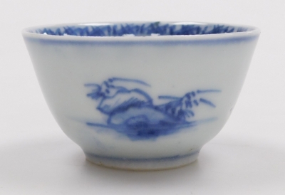 A Nanking Cargo blue and white tea bowl and saucer, painted with a landscape, bears label for Christies lot 5108, together with a 19thC blue and white saucer painted with flowers and foliate scrolls, seal mark, 14cm wide. (3) - 16