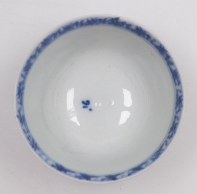 A Nanking Cargo blue and white tea bowl and saucer, painted with a landscape, bears label for Christies lot 5108, together with a 19thC blue and white saucer painted with flowers and foliate scrolls, seal mark, 14cm wide. (3) - 17