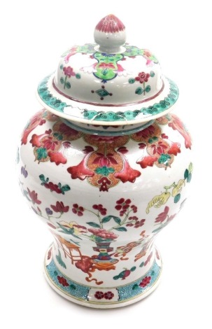 A Chinese porcelain famille rose jar and cover, of baluster form, decorated with flowers, vase, table etc., in coloured enamels, unmarked, 40cm high, (AF).