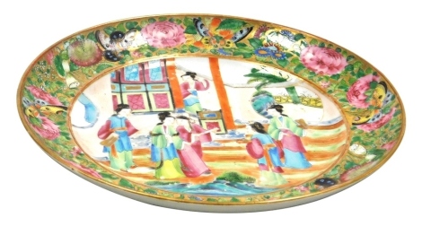 A 19thC Chinese Canton famille rose dish, decorated with figures in interior scene surrounded by a border of butterflies and flowers in coloured enamels, unmarked, 25cm diameter.