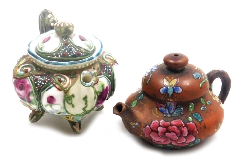 Two miniature teapots, comprising a Chinese Yixing example, decorated in enamels with flowers and butterflies, 4cm high, (AF), and a Japanese Nippon moriage decorated teapot, 5cm high.