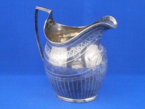 A George III silver helmet shaped milk jug decorated with flutes and leaves