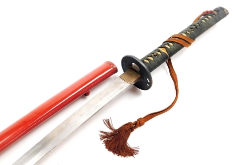 A Japanese katana sword, with plain pommels, shagreen and cord bound handle, cast iron tsuba, brass habaki, steel blade, in a red lacquer scabbard, blade 68.5cm wide.