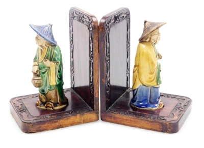 A pair of Chinese hardwood bookends, set with mudman figures and a carved floral border, 16cm high.