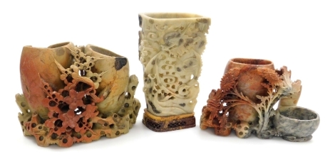 Three Chinese soapstone brush pots, each carved with flowers, the largest 20cm high.