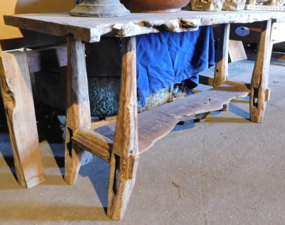 A driftwood two tier side table, 83cm high, the top approximately 59cm x 190cm. Note: VAT is payable on the hammer price of this lot at 20%.