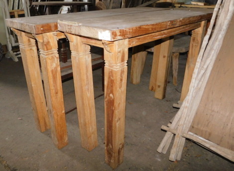 A reclaimed teak console or side table, with a rectangular top raised on strut supports, 85cm high, the top 140cm x 40cm, and another similar, the top 40cm x 120cm. Note: VAT is payable on the hammer price of this lot at 20%.