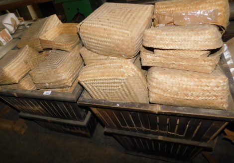 A quantity of woven wicker baskets, each approx 24cm wide, contained in two wooden slatted containers, each of tapering form, 57cm high. Note: VAT is payable on the hammer price of this lot at 20%.
