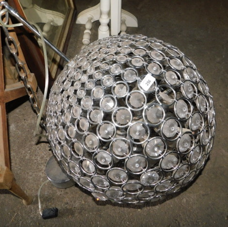 A hanging light fitting, of globular form, inset with various faceted crystals, approx 140cm drop. Note: VAT is payable on the hammer price of this lot at 20%.