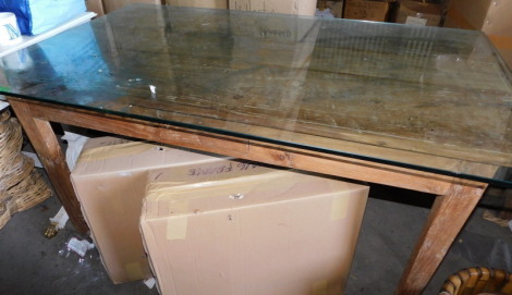 A reclaimed pine kitchen table, the rectangular top on square legs, 76cm high, the top 79cm x 143cm, with an associated glass top. Note: VAT is payable on the hammer price of this lot at 20%.