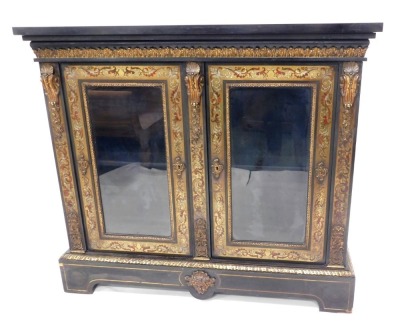 A 19thC ebonised and Boulle side cabinet, the rectangular top with a leaf cast frieze above two glazed doors, each flanked by gilt metal bosses enclosing a shelf, on a shaped base with bracket feet, 114cm high, 130cm wide, 38cm deep.