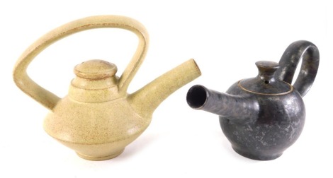 An Ian Rylatt bronze glazed stoneware teapot, with long cannon like spout and shaped handle, impressed mark to handle, and another with a beige coloured glaze, 10cm and 13cm high respectively.