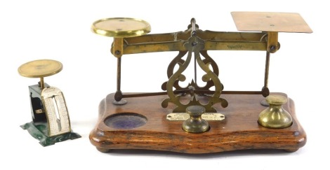 A set of late 19th/early 20thC brass and oak postal scales, with ivorine plaque for inland letter rates, weights incomplete, 27cm wide, and a small tin and brassed postal scale.