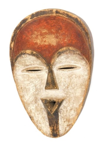 A 20thC African tribal Tsago wall mask, decorated in red and cream, 32cm high.