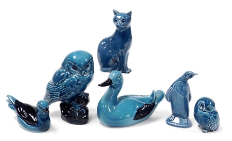 A group of six Poole blue glazed pottery figures of birds, including a penguin and two owls, together with a seated figure of a Siamese cat.