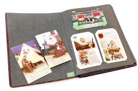 A postcard album, containing early 20thC greetings cards, sentimental cards, together with photographs.