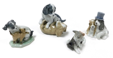 A Lladro Porcelain figure of a kitten, and three Nao Porcelain figures of bride and groom dogs, two puppies playing, and a puppy with a Siamese cat.