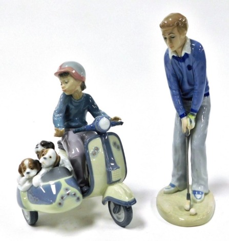 A Lladro Porcelain figure group of a boy on a Lambretta, with side car, holding three puppies, number 5794, together with a Casades porcelain figure of a male golfer. (2)