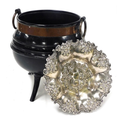 A cast iron and copper bound cauldron, with ring handles, 31cm high, together with a silver plated dish, embossed with flowers and rococo scrolls, 28cm wide. (2)