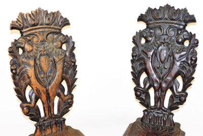 A pair of early 19thC Italian oak Sgabello hall chairs, with foliate carved crest rails, the back carved with a pair of rampant lions holding branches of pomegranates, flanking a central shield, with an engraved solid seat, raised on a grotesque mask base - 2