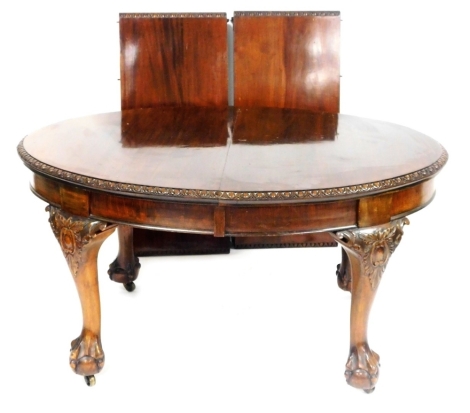 A Victorian mahogany oval wind out dining table, with two additional leaves, the top with a gadrooned border, raised on foliate carved cabriole legs on ball and claw feet, raised on castors, 74cm high, 140cm wide, 234cm extended, 103cm deep.