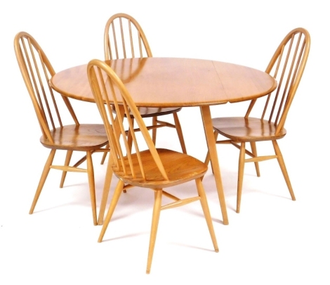 An Ercol light elm drop leaf dining table, raised on outswept square legs, 71cm high, 63cm wide, 121cm extended, 114cm deep, together with four Ercol light elm stick back Windsor chairs, with loose cushion seats.