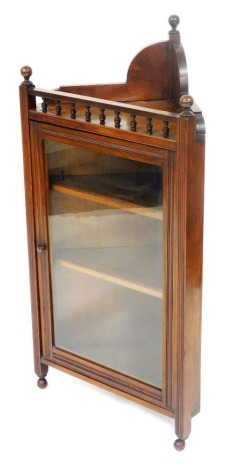 A Victorian mahogany corner display cabinet, the galleried top over a glazed door enclosing two shelves, raised on channelled square supports, on ball feet, 112cm high, 55cm wide, 33cm deep.