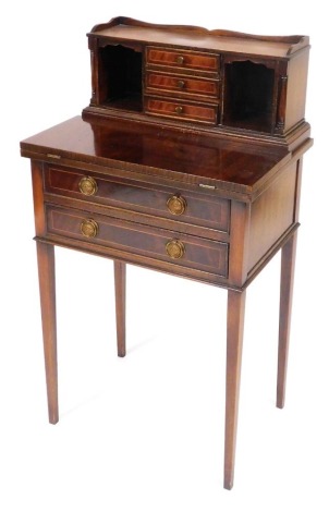 A reproduction Georgian mahogany lady's writing table, the galleried top super structure with three drawers flanked by recesses and turned pilasters, over a hinged writing slope and two frieze drawers, raised on tapering square legs, 99cm high, 54.5cm wid