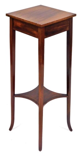 An Edwardian mahogany and cross banded jardiniere stand, raised on square slender tapering outswept legs, united by an under tier, 92cm high, 32cm wide, 33cm deep.