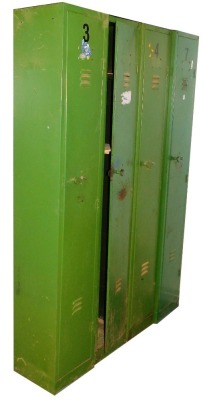 Four green metal lockers, the hinged doors enclosing an arrangement of shelves, each 183cm high, 31cm wide, 30cm deep.