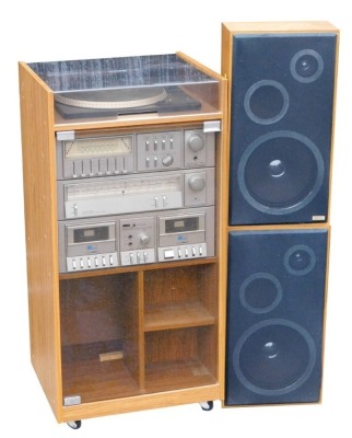 An Amstrad music system, with turntable, stereo tuner, double cassette deck, stereo amplifier, in case, 86cm high, 43cm wide, 38cm deep, together with a pair of speakers.