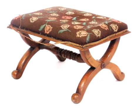 A Victorian walnut X frame stool, with a floral wool work overstuffed seat, united by a turned stretcher, 61cm wide.