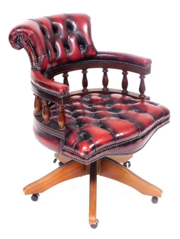 A mahogany and red leather captain's chair, with button back and seat, on castors, 62cm wide. The upholstery in this lot does not comply with the 1988 (Fire & Fire Furnishing) Regulations, unless sold to a known exporter or upholsterer it will be cut from