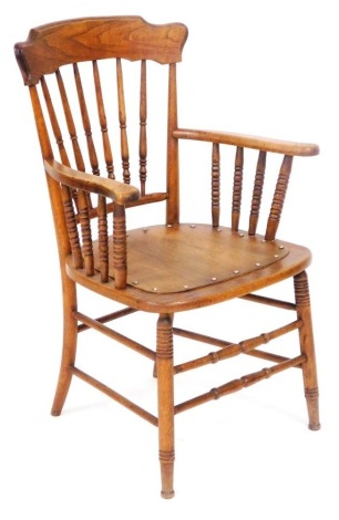 A 19thC oak kitchen carver chair, with a shaped crest rail, spindle back, solid seat with loose cushion, raised on turned legs, united by turned stetchers, 62cm wide.