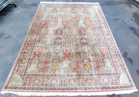 A Persian Heriz cream ground silk rug, with fifty six central panels decorated with tree of life, plants and boteh motifs, within a similar border pattern and outer border of leaves and scrolls, 275cm x 380cm.